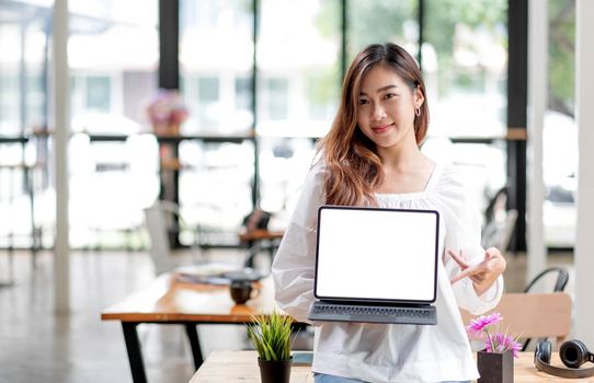 Happy young asian woman clothes on white background. People lifestyle concept. Mock up copy space. Hold laptop pc computer with blank empty screen.