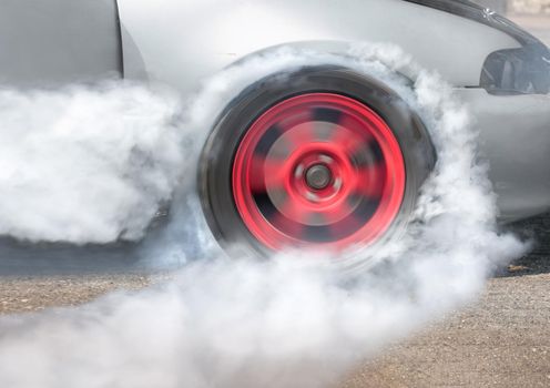 Drag racing car burns rubber off its tires in preparation for the race