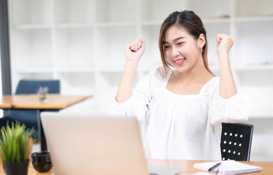 Asian business woman are delighted and happy with the work they do on their laptop and taking notes at the office..