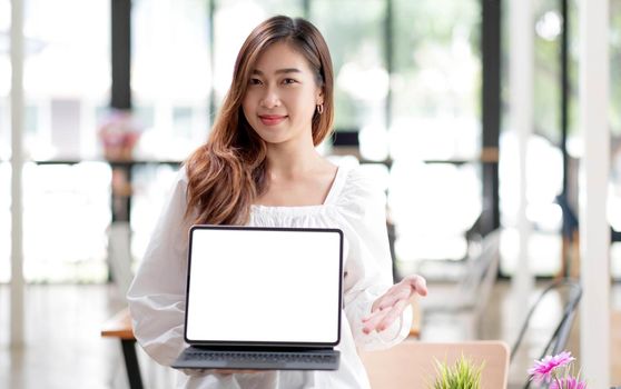 Happy young asian woman clothes on white background. People lifestyle concept. Mock up copy space. Hold laptop pc computer with blank empty screen.