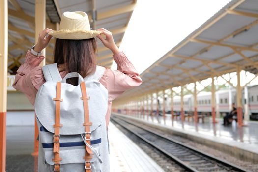 young asian woman  backpacker traveler with backpack at train station. journey trip travel concept