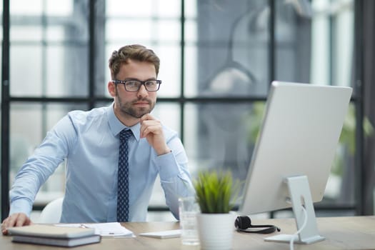 Young cheerful businessman working at office