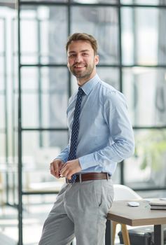 Young cheerful businessman working at office