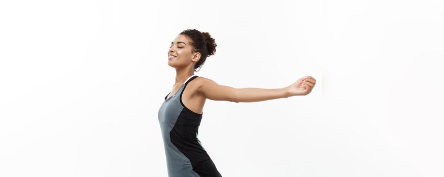 Healthy and Fitness concept - Portrait of young beautiful African American with her hands outstretched and closing eyes feeling relax. Isolated on white studio background