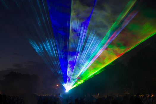 green and blue laser beams in a city park.celebrations in the city.