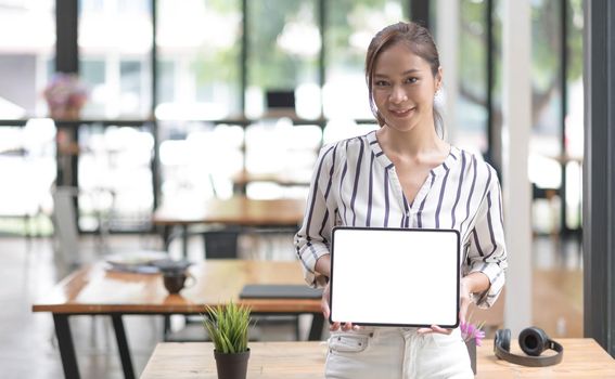 Mockup image of a smiley Asian beautiful woman holding and showing black mobile phone with blank white screen..