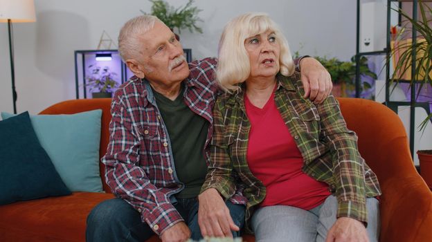 Sad senior elderly family couple grandparents man woman sitting at home thinks over lonely life or problems, crisis, suffers from unfair situation. Illness, anxiety, depressed, feeling bad annoyed