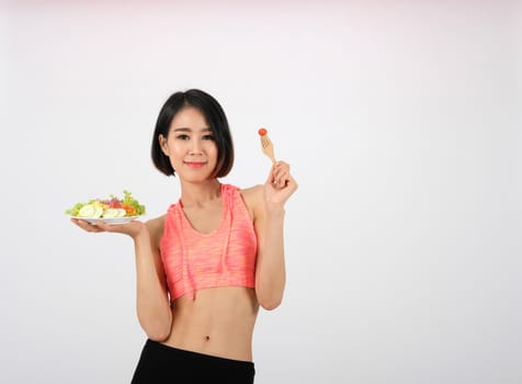 sporty fitness woman in sportswear with vegetable salad bowl on white background. healthy sport lifestyle