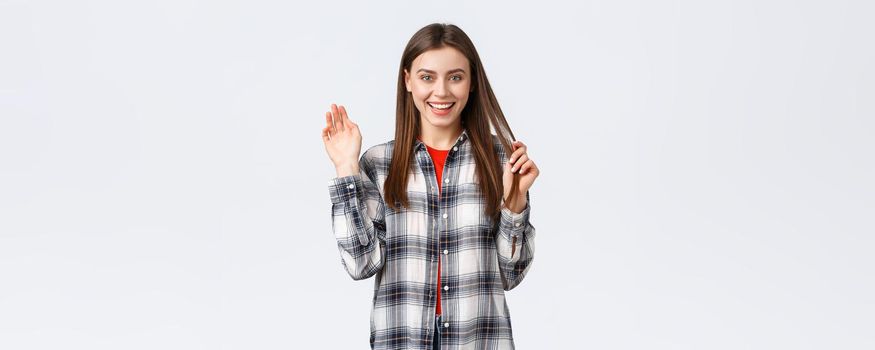 Lifestyle, different emotions, leisure activities concept. Friendly attractive young woman saying hi or bye, waving hand in greeting with happy enthusiastic smile, meeting fellow students.