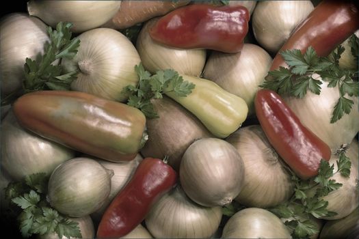 A large number of different varieties of pepper and onion together with parsley leaves