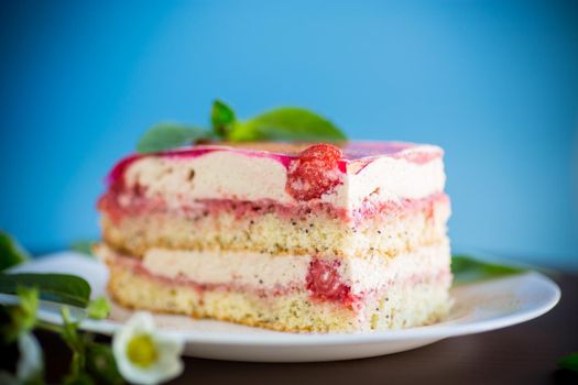 strawberry poppy cake with cream in a plate on aon a blue background