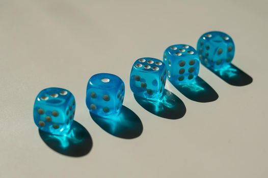 Five transparent blue dice on a white table