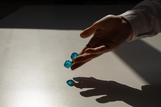 Woman throws a pair of blue transparent dice