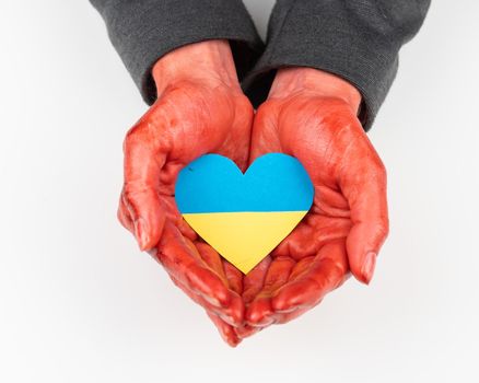 Woman with hands covered in blood holding a heart with the flag of ukraine on a white background