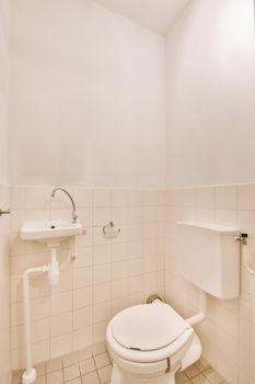 Interior of simple toilet room with white appliances