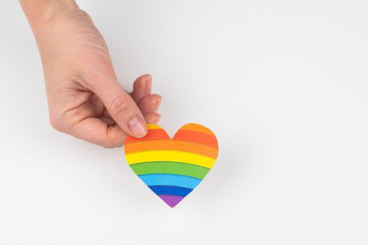 Female hands with rainbow paper heart isolated on white background