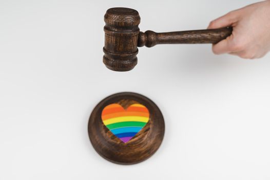 The judge hits a heart with a rainbow flag with a gavel