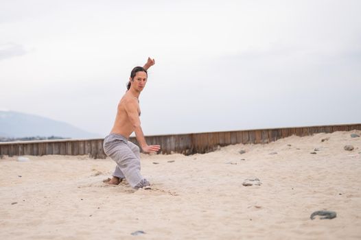 Caucasian man with long hair practicing qigong outdoors