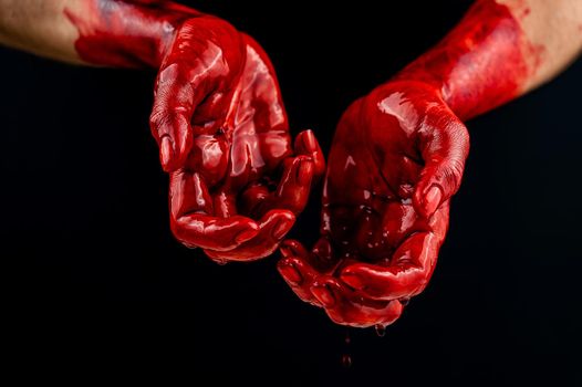 Women's hands in blood on a black background