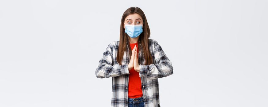 Different emotions, covid-19 pandemic, coronavirus self-quarantine and social distancing concept. Hopeful enthusisatic girl, volunteer in medical mask, asking please, begging help, hold hands in pray.