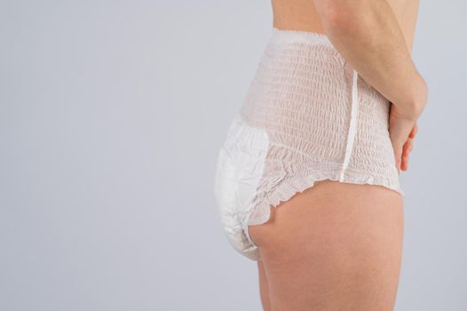 Side view of a Woman in adult diapers on a white background. Incontinence problem