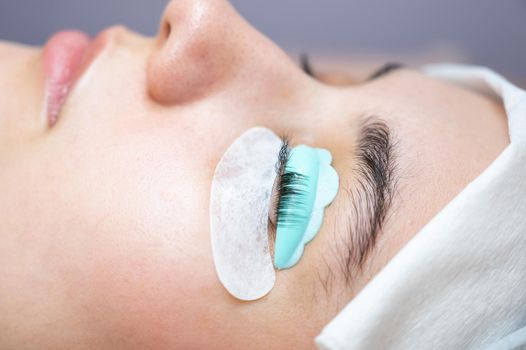 Close-up portrait of a woman in a beauty salon on eyelash lamination procedure