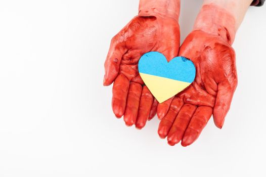 Woman with hands covered in blood holding a heart with the flag of ukraine on a white background