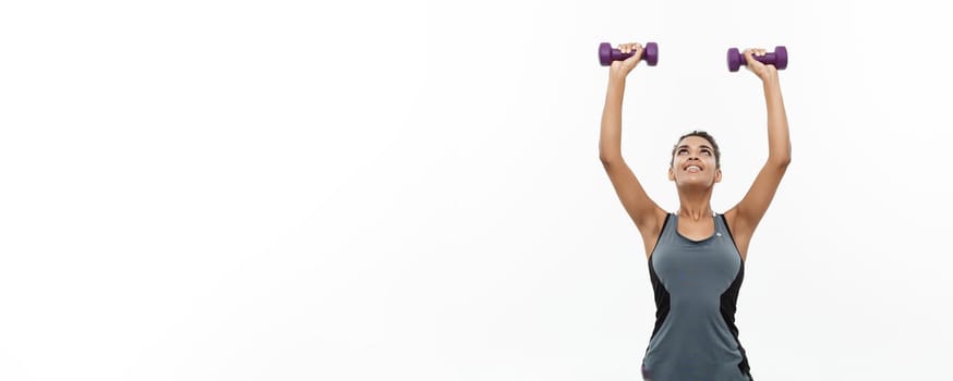 Healthy and Fitness concept - Beautiful American African lady in fitness clothes workout with dumbbell. Isolated on white background