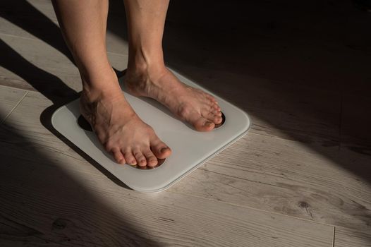 Close-up of female legs on electronic scales