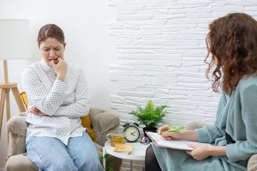 Worried caucasian woman at a session with a psychotherapist