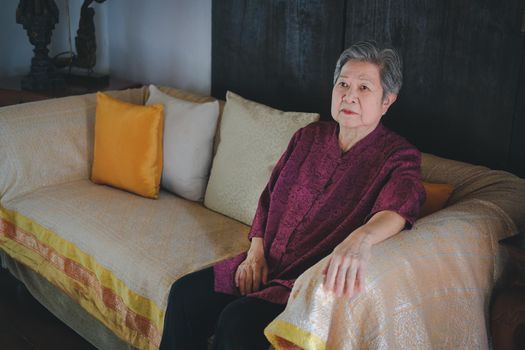 old elderly senior elder woman resting relaxing on sofa couch in living room interior