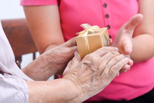 Elderly woman receiving a gift from daughter
