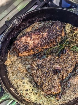 basting premium steak on iron pan on stove