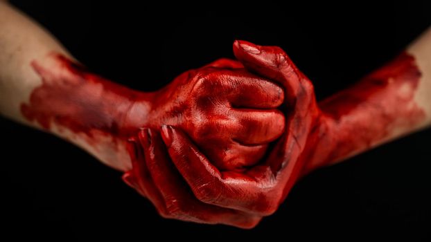 Women's fists in blood on a black background. Fist and palm