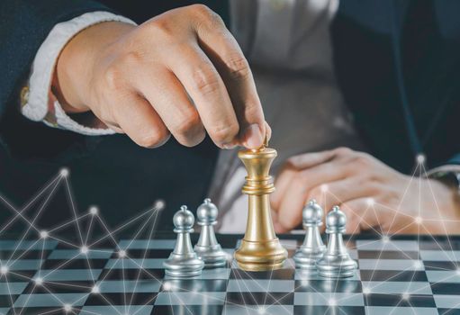 Hand of businessman holding gold king chess on stock market or forex trading graph chart with cityscape image economy trend for digital financial investment.Management or leadership strategy concept.