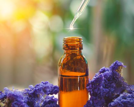 Essential oil falling from glass dropper into brown bottle organic bio alternative medicine. Beauty and spa Concept.