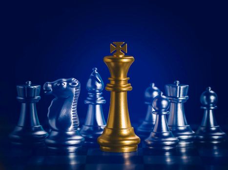 Golden king chess is surrounded by falling around silver chess pieces  to fighting with teamwork to victory, business strategy concept and leader and teamwork concept for success.