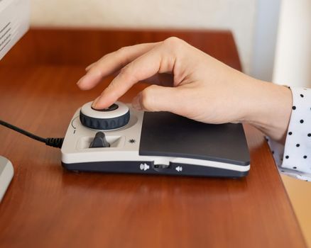 A woman uses a special magnification device for the visually impaired