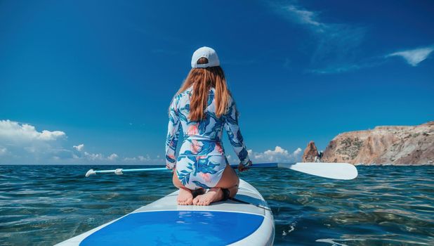 SUP Stand up paddle board. Young woman sailing on beautiful calm sea with crystal clear water. The concept of an summer holidays vacation travel, relax, active and healthy life in harmony with nature