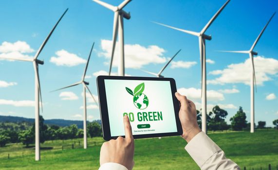 Green business transformation for environment saving and ESG business concept. Businessman using tablet to set corporate goal toward environmental friendly management and alternative clean energy use.