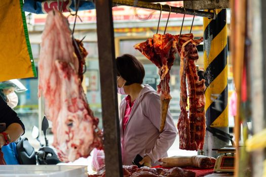 Fresh meat hanging at meat vendor in a Taiwan market