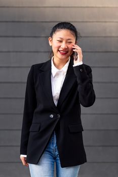 smiling asiatic businesswoman talking on the phone, concept of entrepreneurship and business