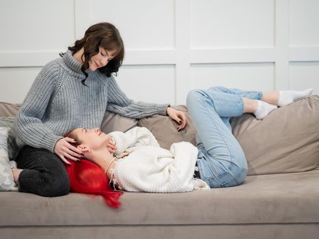 Young girls hugging while lying on the couch. Unisexual love