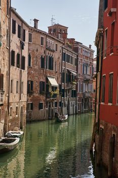 Venice, Italy - 10.12.2021: Traditional canal street with gondolas and boats in Venice, Italy. High quality photo