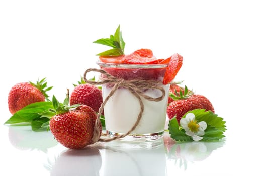 sweet homemade yogurt with strawberry jam and fresh strawberries in a glass, isolated on white background.