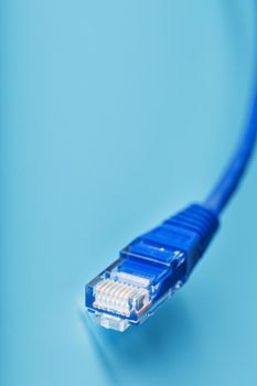 A coil of an Internet network cable for data transmission on a blue background. Patch cord for LAN cable.