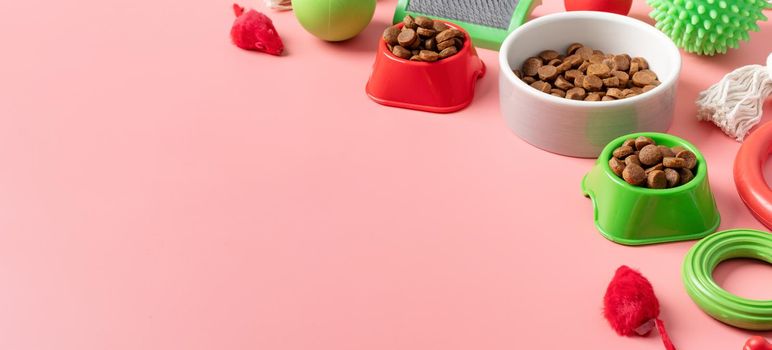Pet care concept, various pet accessories and tools, toys, balls, brushes on pink background, high angle view