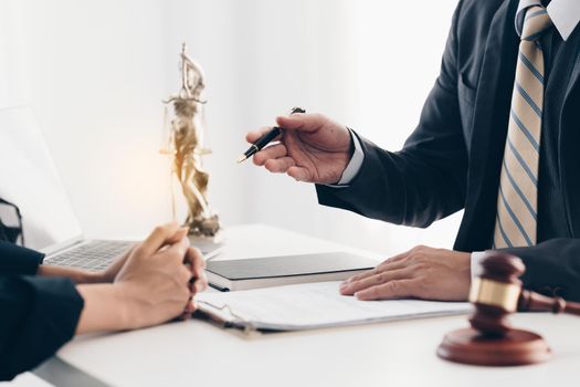 Business woman and lawyers discussing contract papers with brass scale on wooden desk in office. Law, legal services, advice, Justice concept