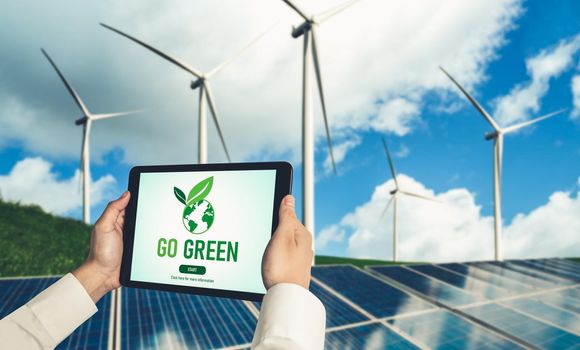 Green business transformation for environment saving and ESG business concept. Businessman using tablet to set corporate goal toward environmental friendly management and alternative clean energy use.