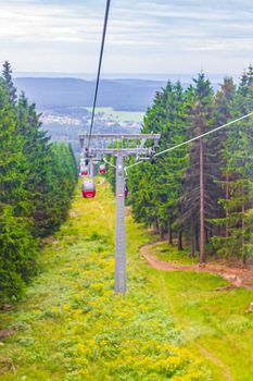 Wurmberg ride with the red gondola cable car railway with panorama view to mountain landscape of Braunlage Harz Goslar in Lower Saxony Germany.